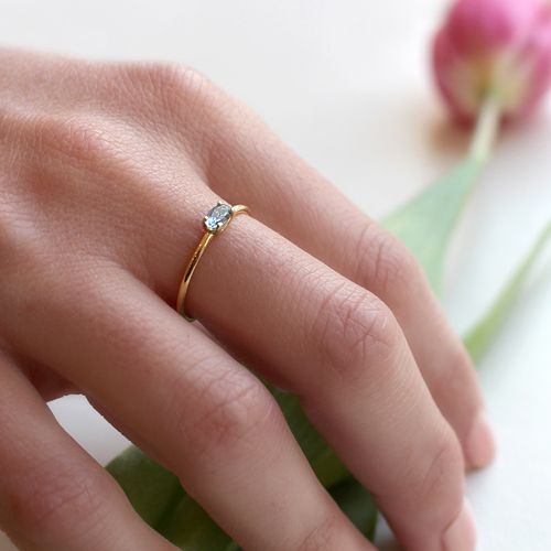 Anillo de mujer discreto y elegante de oro amarillo de 18k con aguamarina central oval